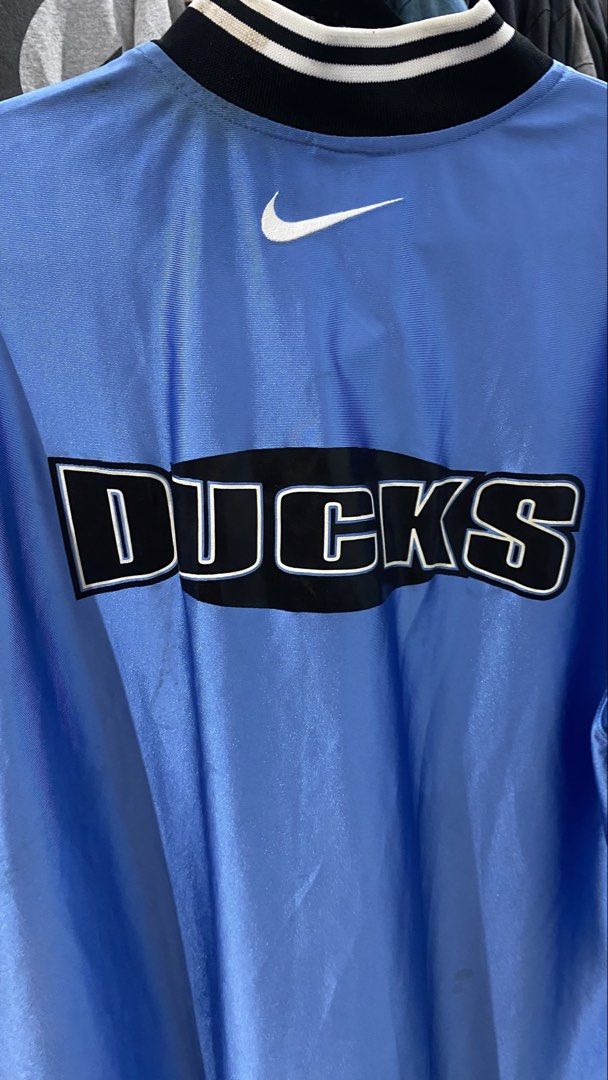 Nike Ducks Light Blue Basketball Jersey (Category: Activewear) located in Porac. Submitted by moethrifter (Listing ID 1444949616, Image 3). Description: - Light blue Nike jersey - 'Ducks' graphic on the back - Nike swoosh logo - NBA logo patch on sleeve - Button-up neckline - Striped collar - Ideal for Ducks fans and basketball lovers.