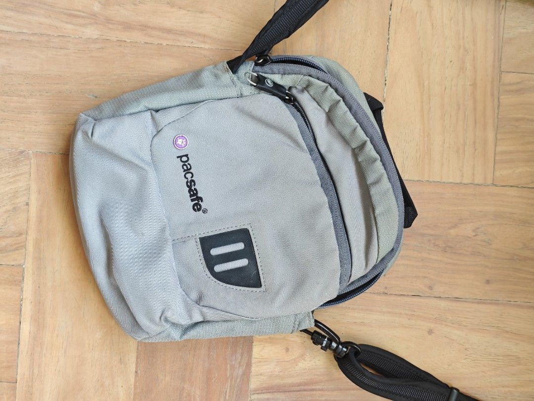 Pacsafe Metrosafe 100 (First-generation) Grey Compact Crossbody Bag (Category: Sling Bags) located in Quezon City. Submitted by woofnfloofph (Listing ID 1444886021, Image 3). Description: Preloved but lightly used only. QC area Vintage Security Features This generation features Pacsafe's classic, heavy-duty safety hardware: eXomesh® Slashguards: Built-in flexible, high-tensile stainless steel wire mesh embedded into the lower front and bottom pan