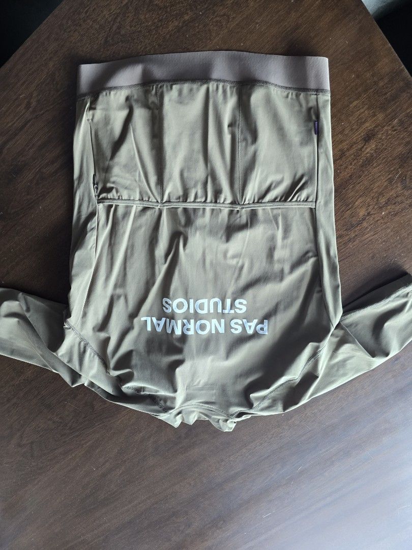 Pas Normal Studios Cycling Jacket Khaki Green (Category: Activewear) located in Quezon City. Submitted by mr.stealdeal (Listing ID 1445017543, Image 2). Description: - Pas Normal Studios cycling jacket - Color: Khaki Green - Full zip front closure - Three rear pockets for storage - Elasticated cuffs and hem for a snug fit - Ideal for cycling and outdoor rides - Please check photos for condition details.