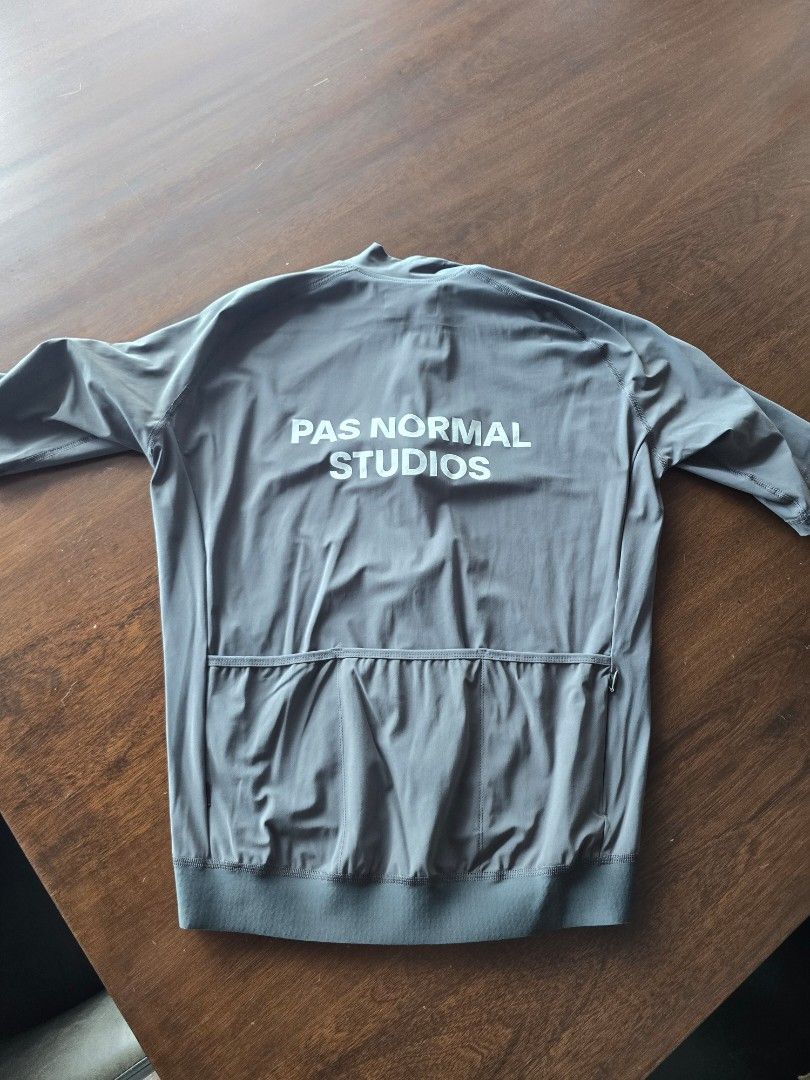 Pas Normal Studios Long Sleeve Cycling Jersey (Category: Activewear) located in Quezon City. Submitted by mr.stealdeal (Listing ID 1445016217, Image 2). Description: - Pas Normal Studios long sleeve cycling jersey - Color: Grey - Brand name prominently displayed on front and back - Three convenient pockets on the back - Full zip closure for adjustable ventilation - Elasticated cuffs and hem for a secure fit - Ideal for cycling enthusiasts.