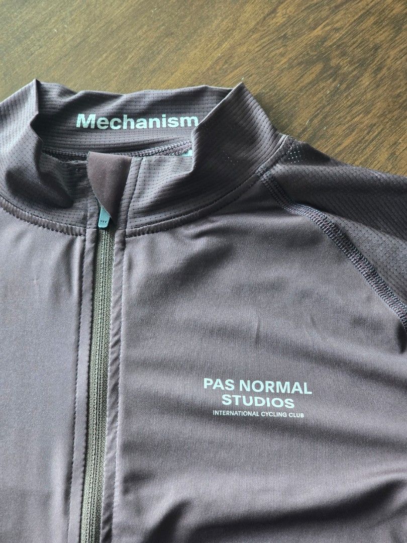 Pas Normal Studios Mechanism Long Sleeve Cycling Jersey (Category: Activewear) located in Quezon City. Submitted by mr.stealdeal (Listing ID 1445015219, Image 2). Description: - Brand: Pas Normal Studios - Model: Mechanism Long Sleeve Cycling Jersey - Color: Dark Purple/Brown - Features: Full zip front, 3 rear pockets - Branding: "Mechanism" text on sleeve, "Pas Normal Studios International Cycling Club" on front - Ideal for: Cycling.