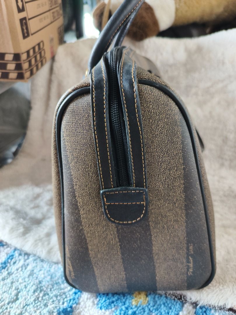 Peculiar Saint Pattern Boston Bag (Category: Luxury Bags & Wallets) located in San Leonardo. Submitted by burgossanleonardo.12345 (Listing ID 1444886218, Image 3). Description: - Classic Fendi Zucca pattern Boston bag - Brown and black striped design - Genuine leather trim and handles - Secure top zipper closure - Convenient front pocket - Interior zippered pocket - Timeless and versatile for everyday use.