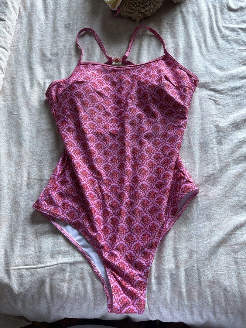 Pink Patterned One-Piece Swimsuit with Sun Clasp (Category: Bikinis & Swimsuits) located in Muntinlupa City. Submitted by stuffbya (Listing ID 1444874488, Image 1). Description: - Adorable pink one-piece swimsuit - Features a vibrant red and pink geometric pattern all over - Thin straps with a unique sun clasp closure at the back - Stylish low back design - Ideal for beach days or pool parties - Designed for a comfortable fit.