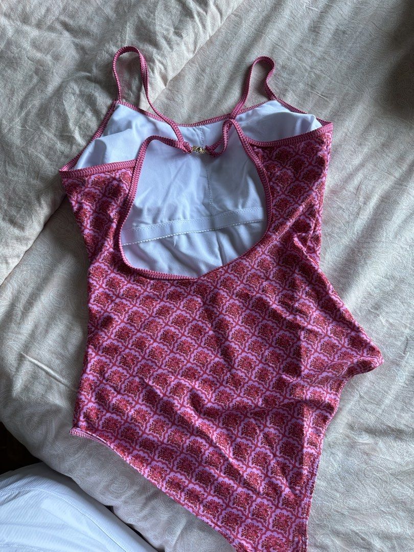 Pink Patterned One-Piece Swimsuit with Sun Clasp (Category: Bikinis & Swimsuits) located in Muntinlupa City. Submitted by stuffbya (Listing ID 1444874488, Image 2). Description: - Adorable pink one-piece swimsuit - Features a vibrant red and pink geometric pattern all over - Thin straps with a unique sun clasp closure at the back - Stylish low back design - Ideal for beach days or pool parties - Designed for a comfortable fit.