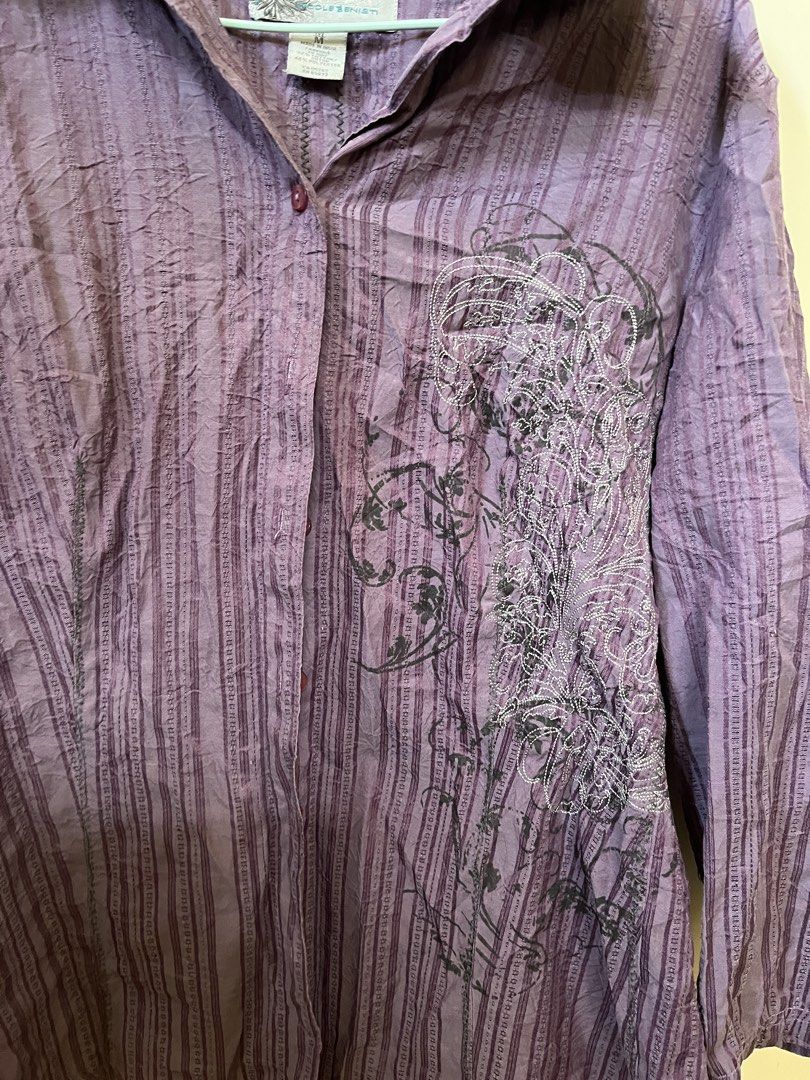 purple punk button down (Category: Shirts) located in Nabua. Submitted by twelvet (Listing ID 1444882458, Image 3). Description: - Unique purple collared shirt - Textured stripe pattern - Cool graphic print on front left - Button-up style with single collar button - Size: Medium (M) - Versatile: Dress up or down.