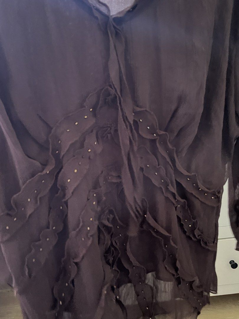 Sheer Ruffle Embellished Blouse (Category: Blouses) located in Nabua. Submitted by twelvet (Listing ID 1444869955, Image 3). Description: - Sheer long-sleeved blouse - Brand: SIMI INTERNATIONAL - Color: Deep brown - Ruffled detailing down the front - Adorned with small beads - Tie neckline - Beautiful fabric drape - Ideal for layering or wearing solo.