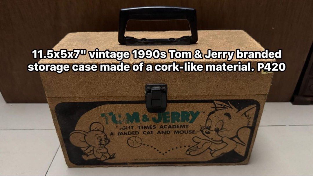Sale! 1990s Tom & Jerry Cork Storage Case (Category: Storage Boxes & Baskets) located in Mandaluyong City. Submitted by elainelawenko (Listing ID 1445189455, Image 1). Description: - Vintage 1990s Tom & Jerry storage case - Made from a unique cork-like material - Dimensions: 11.5 inches (length) x 5 inches (width) x 7 inches (height) - Features a sturdy handle for easy carrying - Secure clasp closure to keep contents safe - Interior lined with bl