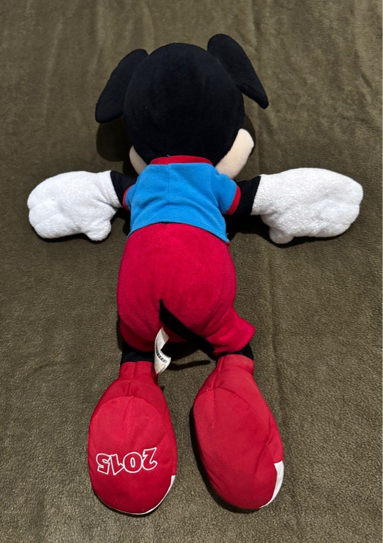 23 inch Authentic Disney Mickey Mouse Plush Toy 2015 (Category: Plushies & Soft Toys) located in Taguig. Submitted by misstangerine (Listing ID 1445163445, Image 2). Description: - Classic Mickey Mouse plush toy - Iconic outfit: red shorts, blue shirt ('Mickey Mouse' print), red shoes - Shoe detail: '2015' printed on the back - Ideal for Disney fans and collectors - Soft and huggable material - bought in Disney California.
