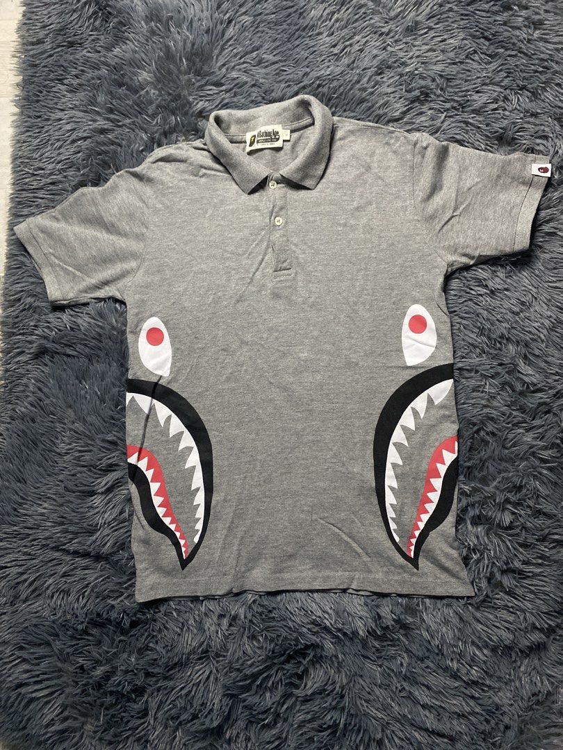 A Bathing Ape BAPE Shark Polo Shirt Grey (Category: Tshirts & Polo Shirts ) located in Manila. Submitted by mysticstar_4e4227 (Listing ID 1445201077, Image 1). Description: - Grey BAPE polo shirt - Features iconic shark graphic - Short sleeves - Collared neckline with button closure - Made in Bangladesh - Tag details visible in photos - Ideal addition to any streetwear collection .