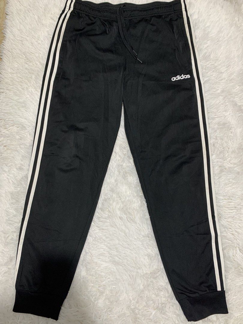 Adidas Black Track Pants with White Stripes (Category: Joggers) located in Iba. Submitted by thriftcoyan (Listing ID 1445185975, Image 1). Description: - Classic Adidas track pants -Size 32-34 -issue dumi lang sa white part - Color: Black with iconic white side stripes - Features: Elastic waistband with drawstring for adjustable comfort - Design: Cuffed ankles - Versatile: Ideal for sports, workouts, or everyday casual wear - Easy to style with a