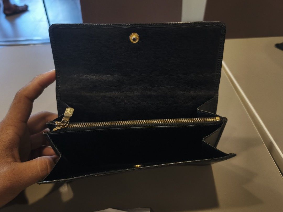 Authentic Louis Vuitton Epi Leather Wallet Black (Category: Luxury Bags & Wallets) located in Ipil. Submitted by ajthriftfinds (Listing ID 1445085956, Image 3). Description: - Authentic Louis Vuitton Wallet - Material: Black Epi Leather - Design: Classic Bifold with Snap Closure - Interior Features: Zippered Coin Pocket, Card Slots - Origin: Made in France - Condition: Good, with some signs of wear.