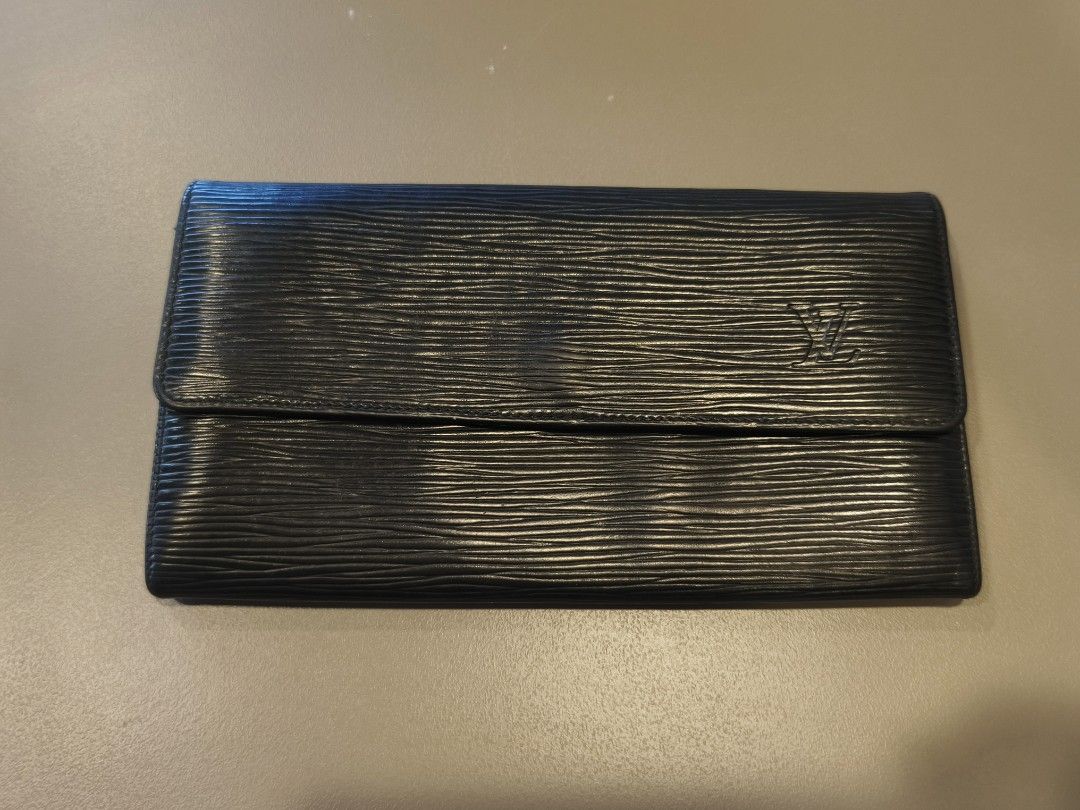 Authentic Louis Vuitton Epi Leather Wallet Black (Category: Luxury Bags & Wallets) located in Ipil. Submitted by ajthriftfinds (Listing ID 1445085956, Image 1). Description: - Authentic Louis Vuitton Wallet - Material: Black Epi Leather - Design: Classic Bifold with Snap Closure - Interior Features: Zippered Coin Pocket, Card Slots - Origin: Made in France - Condition: Good, with some signs of wear.