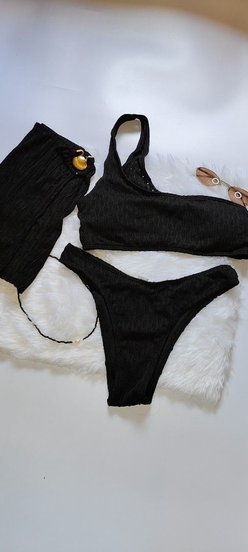 Black Ribbed One-Shoulder Bikini Set with Skirt (Category: Bikinis & Swimsuits) located in Caloocan City. Submitted by catherinef09905 (Listing ID 1445139551, Image 3). Description: - Black ribbed bikini set - One-shoulder top - High-waisted bottoms - Matching ribbed skirt with gold button detail - Subtle textured fabric pattern - Size M on tag - Ideal for beach or pool days.