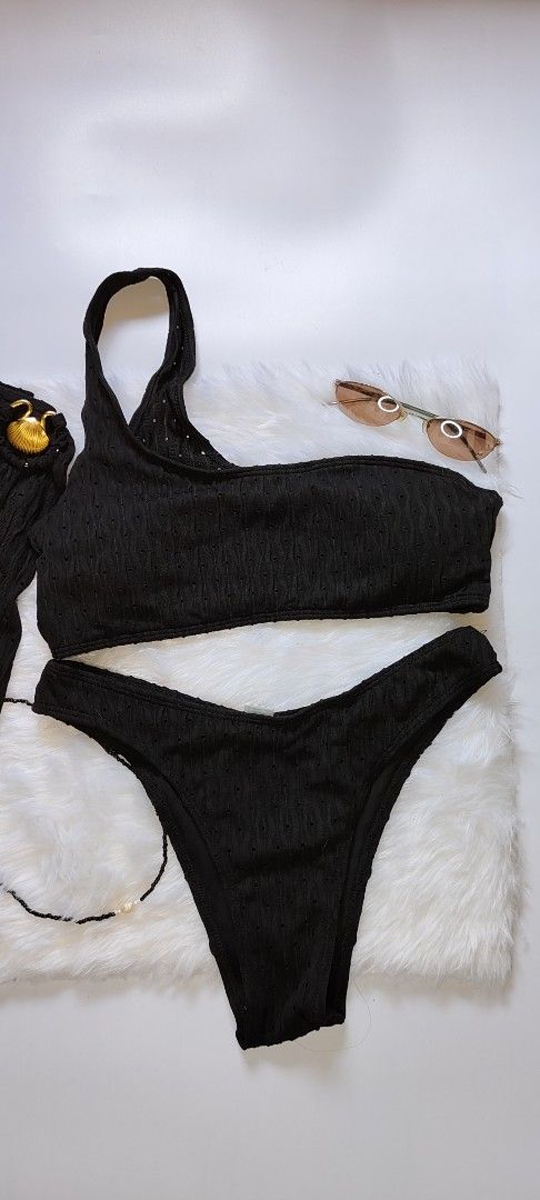 Black Ribbed One-Shoulder Bikini Set with Skirt (Category: Bikinis & Swimsuits) located in Caloocan City. Submitted by catherinef09905 (Listing ID 1445139551, Image 2). Description: - Black ribbed bikini set - One-shoulder top - High-waisted bottoms - Matching ribbed skirt with gold button detail - Subtle textured fabric pattern - Size M on tag - Ideal for beach or pool days.