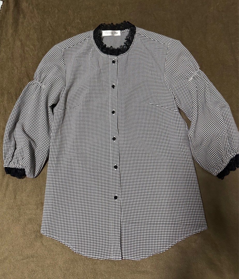 Christian Dior Gingham Blouse with Lace Trim (Category: Blouses) located in Taguig. Submitted by misstangerine (Listing ID 1445167177, Image 1). Description: - Classic black and white gingham pattern - Round neckline with delicate black lace trim - Armpit to armpit: 17.5 inches - Length: 26.5 inches - Functional button-up front with black buttons - Puffy sleeves with elegant lace cuffs - Estimated size: Medium - Ideal for a chic, vintage-inspired