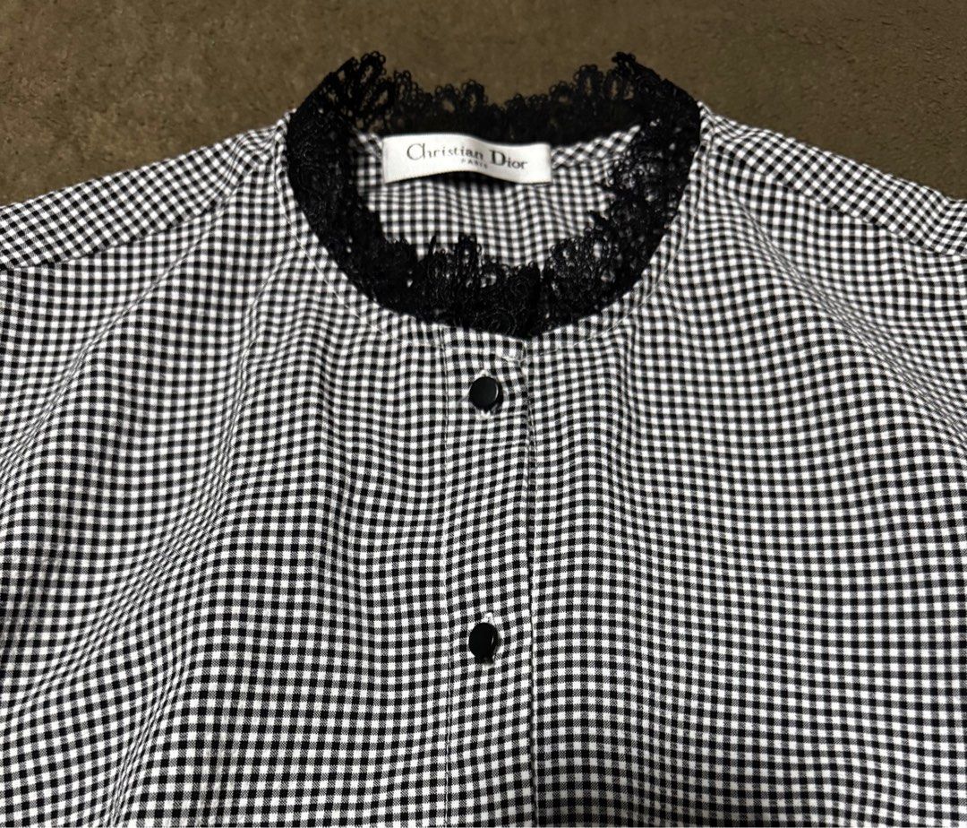 Christian Dior Gingham Blouse with Lace Trim (Category: Blouses) located in Taguig. Submitted by misstangerine (Listing ID 1445167177, Image 2). Description: - Classic black and white gingham pattern - Round neckline with delicate black lace trim - Armpit to armpit: 17.5 inches - Length: 26.5 inches - Functional button-up front with black buttons - Puffy sleeves with elegant lace cuffs - Estimated size: Medium - Ideal for a chic, vintage-inspired