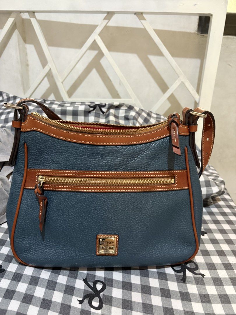 Original Dooney & Bourke Pebble Grain Leather Shoulder Bag (Category: Luxury Bags & Wallets) located in Manila. Submitted by cooltree-5297 (Listing ID 1445220568, Image 1). Description: - Blue pebble grain leather with tan leather trim - Zip top closure - Front zip pocket - Gold tone hardware - Adjustable shoulder strap - Interior pockets - Spacious and ideal for everyday use.