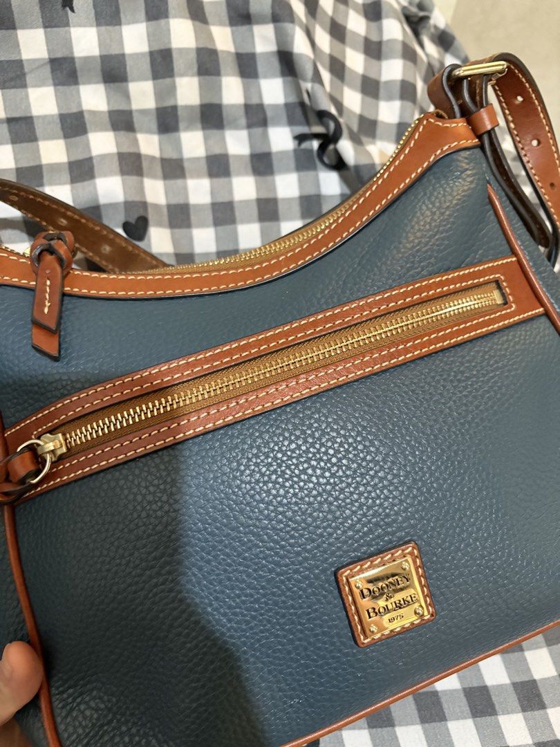 Original Dooney & Bourke Pebble Grain Leather Shoulder Bag (Category: Luxury Bags & Wallets) located in Manila. Submitted by cooltree-5297 (Listing ID 1445220568, Image 3). Description: - Blue pebble grain leather with tan leather trim - Zip top closure - Front zip pocket - Gold tone hardware - Adjustable shoulder strap - Interior pockets - Spacious and ideal for everyday use.