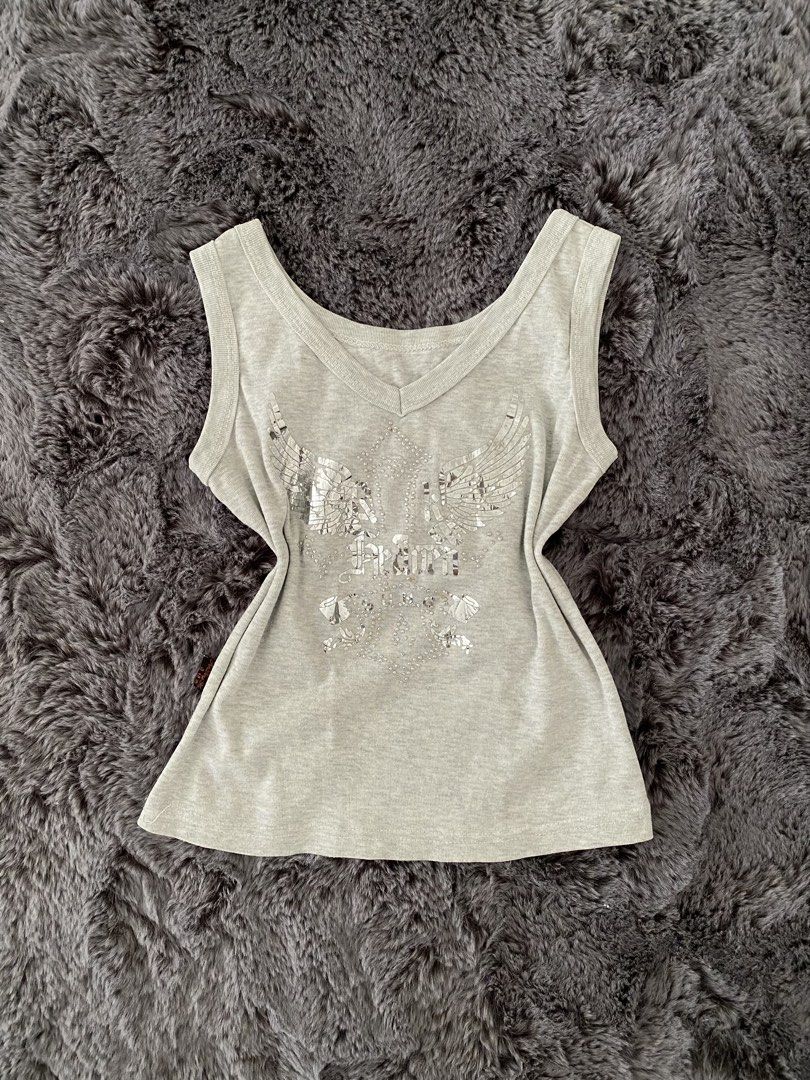 Grey Tank Top with Rhinestone Wings Graphic (Category: Sleeveless) located in Angeles City. Submitted by annrinaaa (Listing ID 1445112627, Image 1). Description: - Grey V-neck tank top - Features a cool rhinestone graphic with wings and text - Sparkly details all over the front - Sleeveless design - Great for casual wear or layering.