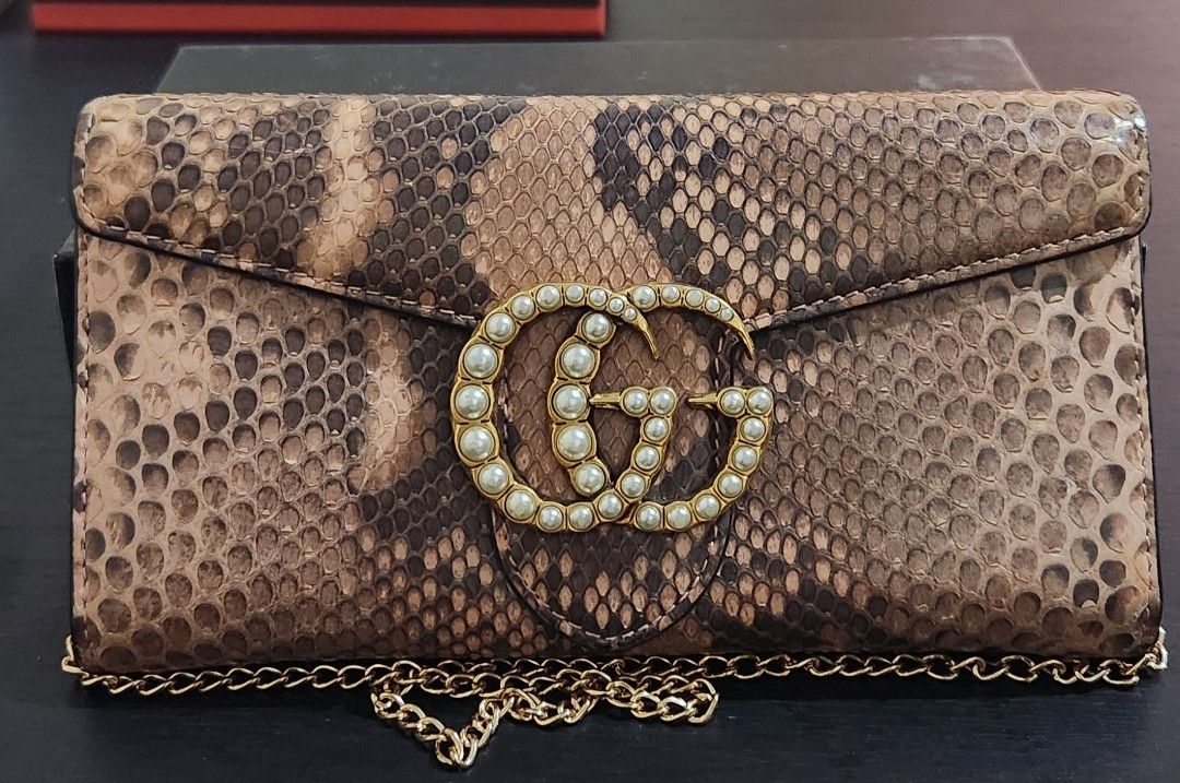 Gucci GG Marmont Python Chain Wallet (guaranteed) (Category: Luxury Bags & Wallets) located in Caloocan City. Submitted by wearandcarry (Listing ID 1403335960, Image 2). Description: - Gucci GG Marmont chain wallet - Snakeskin exterior - Pearl-embellished GG logo - Chain strap - Flap closure - Brown and beige color palette - Rectangular shape - Textured finish.