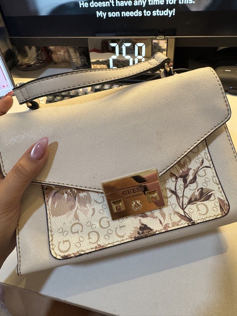 Guess Cream Floral Shoulder Bag (Category: Shoulder Bags) located in Baguio. Submitted by dmrayat (Listing ID 1445224391, Image 1). Description: - Cream-colored Guess shoulder bag - Features a floral print panel on the front flap - Subtle Guess logo incorporated into the floral print - Interior lining with Guess logo pattern - Comes with a shoulder strap - Ideal for everyday use.