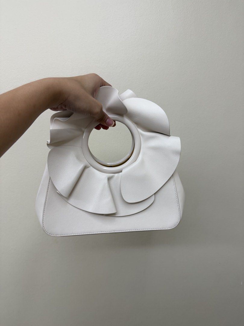 Kate Spade Flora Bracelet (Category: Luxury Bags & Wallets) located in Manila. Submitted by tashvintagefinds (Listing ID 1445194847, Image 2). Description: - Kate Spade Flora Bracelet Bag - Condition is very nice and like new - Nice white color - With strap - Only flaw: the petal on the handle is a bit folded - Negotiable.