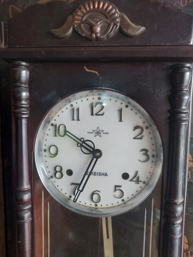 Keisha Wooden Mantel Clock with Pendulum (Category: Clocks) located in Quezon City. Submitted by jpnvintageonline (Listing ID 1445139704, Image 2). Description: - Vintage Keisha mantel clock - Dark wood casing with decorative carvings - White face with black Roman numerals - Features a swinging pendulum - Includes winding key - Perfect for display or as a functional timepiece - Adds a classic touch to any room.