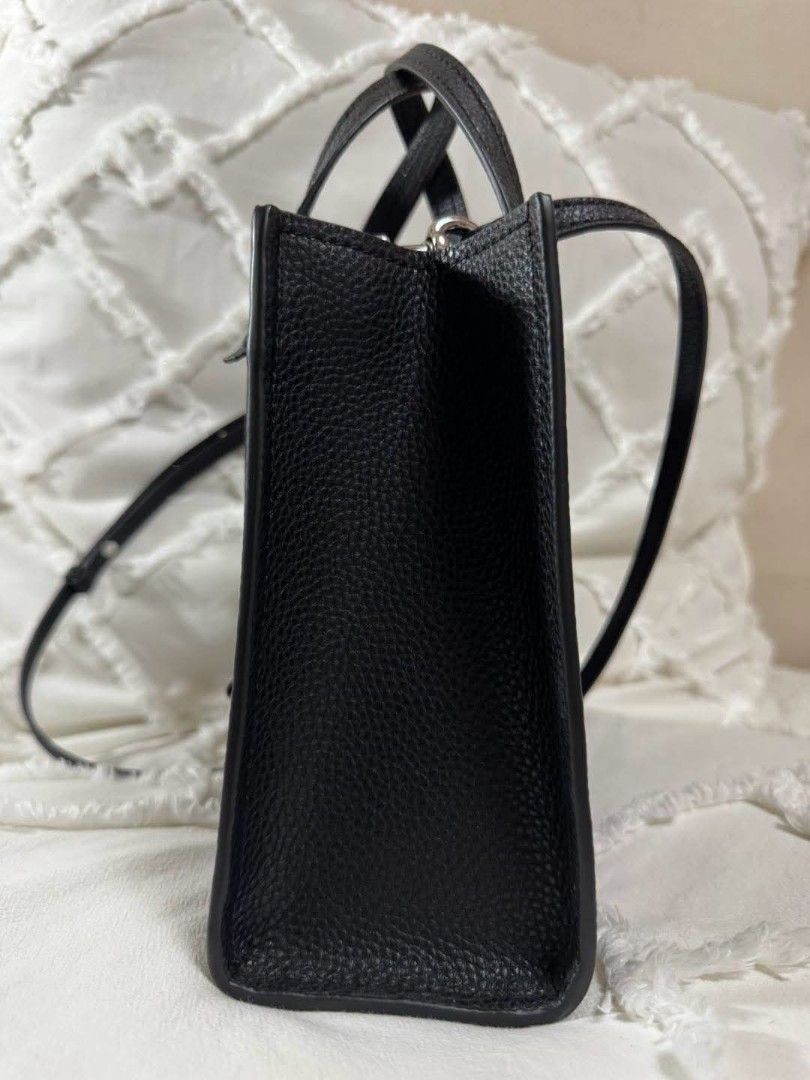 Marc Jacobs The Tote Bag Black Leather (Category: Luxury Bags & Wallets) located in Bulacan. Submitted by vintage_purge (Listing ID 1445130909, Image 3). Description: - Authentic Marc Jacobs black leather tote bag - Features elegant top handles - Comes with a detachable crossbody strap for versatile wear - Adorned with a chic padlock detail on the front - White Marc Jacobs logo printed for a classic touch - Ample interior space to carry all your 