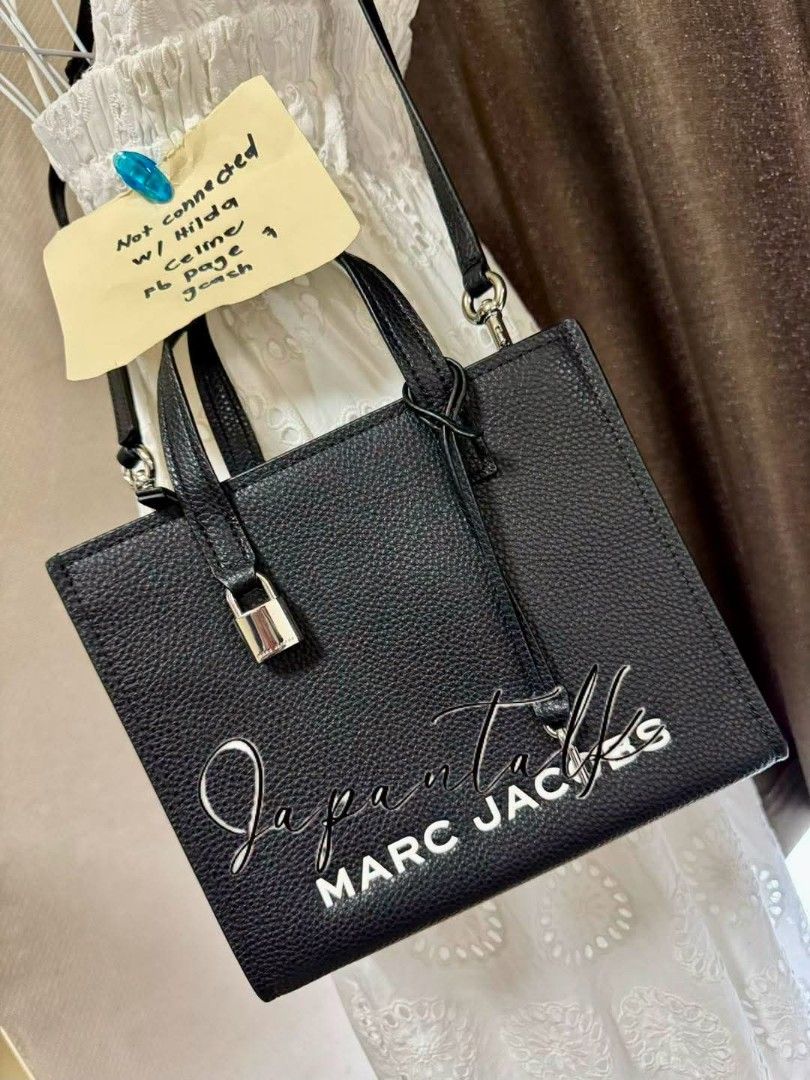 Marc Jacobs The Tote Bag Black Leather (Category: Luxury Bags & Wallets) located in Bulacan. Submitted by vintage_purge (Listing ID 1445130909, Image 2). Description: - Authentic Marc Jacobs black leather tote bag - Features elegant top handles - Comes with a detachable crossbody strap for versatile wear - Adorned with a chic padlock detail on the front - White Marc Jacobs logo printed for a classic touch - Ample interior space to carry all your 