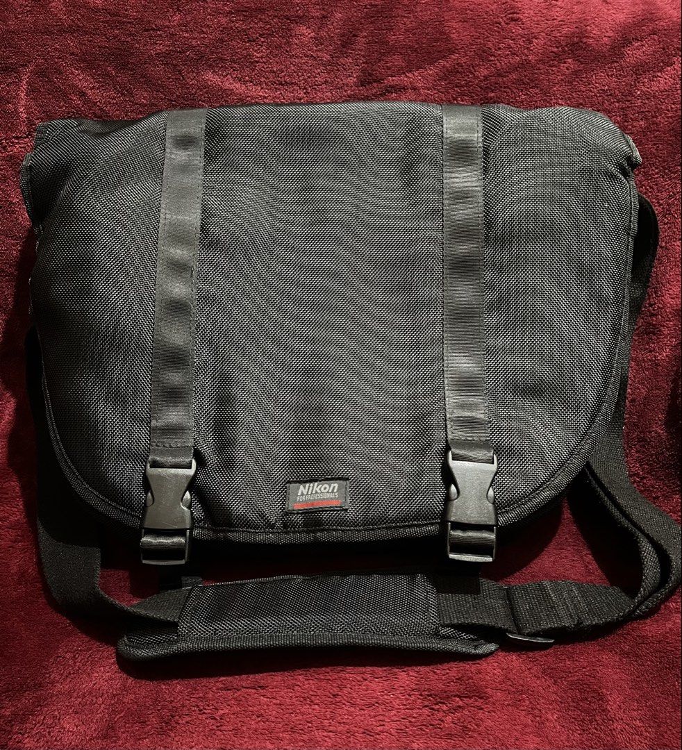 Nikon Black Messenger Camera Bag (Category: Camera Bags & Carriers) located in La Trinidad. Submitted by whatnotcollections (Listing ID 1445177776, Image 1). Description: - Black Nikon messenger bag - Padded shoulder strap for comfort - Thick foam padding on the main compartment. - Front flap with two buckle closures - Durable material - Ideal for camera gear or everyday essentials. - Inside detachable dividers not included. - Can also be used as