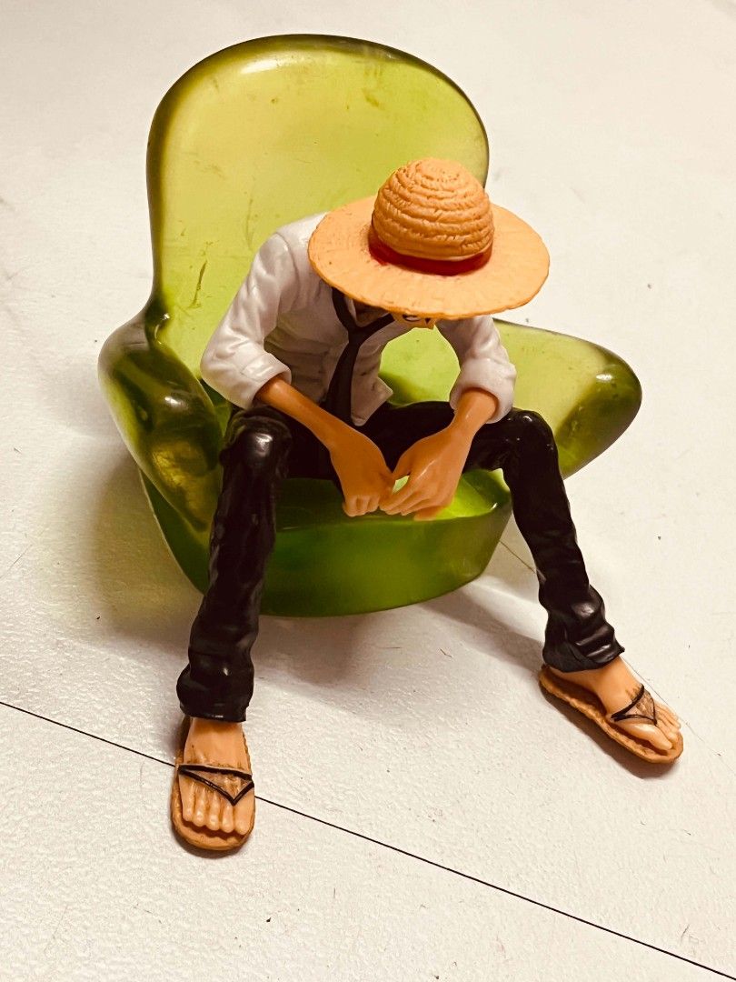 One Piece Monkey D. Luffy Figure Sitting on Chair (Category: Figurines & Statues) located in Manila. Submitted by joanngoter49528 (Listing ID 1445231987, Image 1). Description: - Monkey D. Luffy figure - Sitting pose on a green chair - Iconic straw hat, white shirt, black pants, and sandals - Highly detailed craftsmanship - Ideal for anime collectors and display.