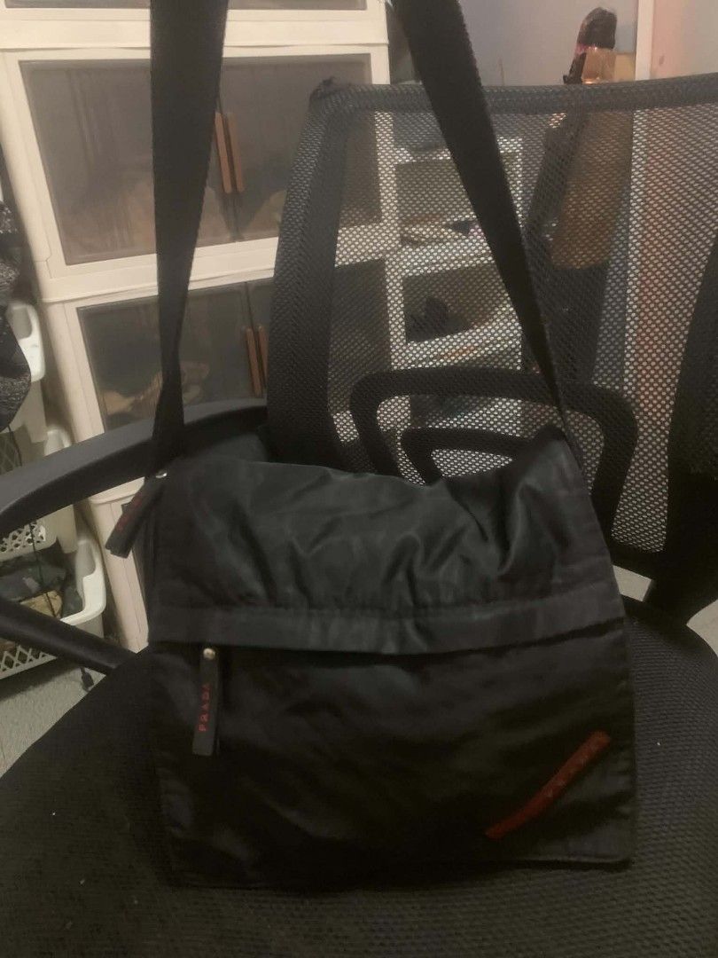 Prada Black Nylon Crossbody Bag (Category: Luxury Bags & Wallets) located in Quezon City. Submitted by ukaybag.ph09 (Listing ID 1445052674, Image 1). Description: - Prada crossbody bag - Durable nylon material - Front pocket with signature red Prada logo - Adjustable strap with metal buckle - Secure zipper closure - Minor marks on front (please check photos for details) - Ideal for everyday wear.