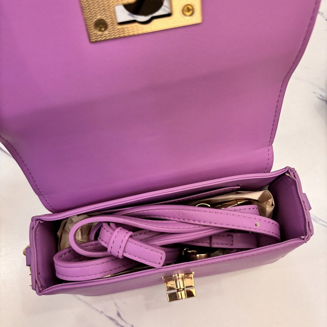 Purple Mini Purse/Crossbody Bag (Category: Purses & Pouches) located in Cainta. Submitted by angeli.6229 (Listing ID 1445103711, Image 2). Description: - Purple mini bag - Features a stylish gold chain strap - Secure gold clasp closure - Compact size: approximately 6 inches wide - Ideal for carrying your essentials - Great for evening events or adding a vibrant touch to any outfit.