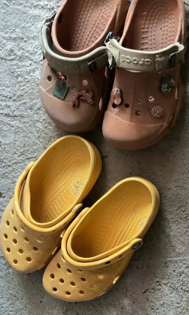 TAKE ALL Crocs Clogs with Jibbitz Charms (Category: Slippers and slides) located in Manila. Submitted by declutterthisandthat (Listing ID 1445061197, Image 3). Description: - Bundle includes two pairs of used Crocs clogs. - One pair is brown and features Jibbitz charms. - The brown pair's strap has the Crocs logo. - The second pair is yellow. - Both pairs are sold as a set. !!! need lang i wash ng water marumi lang sa pic!!!! isang classic orange