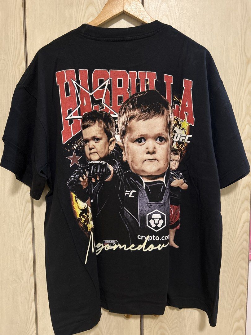 UFC Hasbulla T-Shirt Black (Category: Tshirts & Polo Shirts ) located in Makati City. Submitted by leannd (Listing ID 1445155355, Image 2). Description: - Black UFC T-Shirt - Features Hasbulla graphic print on front and back - Includes Hasbulla's face and signature - UFC logo visible - Ideal for MMA and Hasbulla fans - Short sleeves and crew neck design - Made from comfortable fabric.