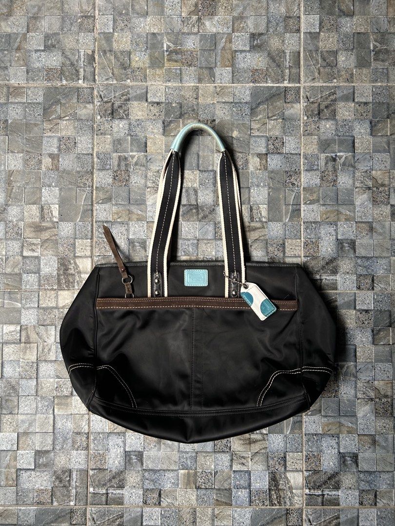 Vintage Coach Hampton Nylon tote bag (Category: Tote Bags) located in Quezon City. Submitted by commonwealthpickerph (Listing ID 1445137687, Image 1). Description: Vintage Coach Hampton Nylon tote bag - 20 width // 12 length - Material: Black nylon with brown leather trim - Accents: Light blue on handles and matching luggage tag - Interior: Multiple compartments for organization - Straps: Comfortable for carrying - Style: Great everyday tote bag 