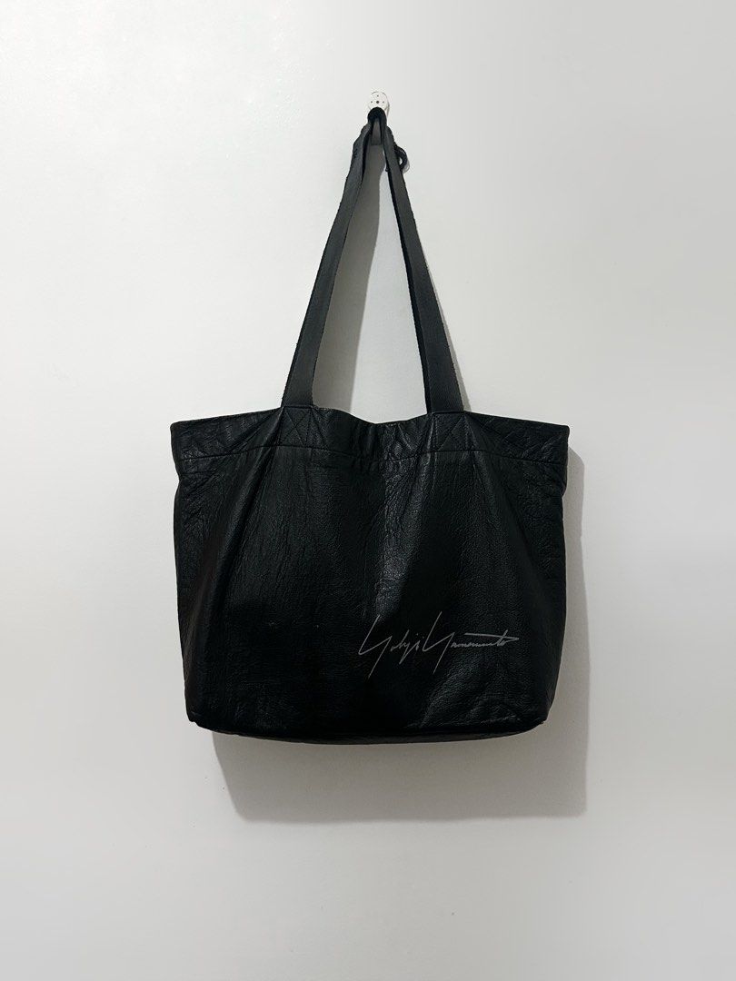 Yohji Yamamoto Black Leather Tote Bag (Category: Luxury Bags & Wallets) located in Mabalacat. Submitted by rotten.closet (Listing ID 1445086330, Image 1). Description: - Authentic Yohji Yamamoto black leather tote bag - Made in Japan - Features designer's signature - Includes a portrait patch inside - Note: Some distress on the strap, as pictured in the last photo.
