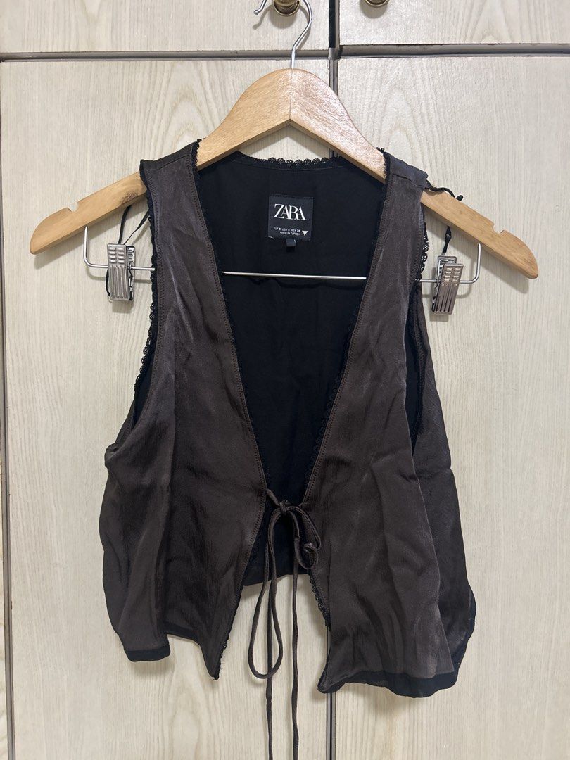 Zara Brown Tie-Front Vest (Category: Sleeveless) located in Makati City. Submitted by leannd (Listing ID 1445169302, Image 1). Description: - Zara brown vest - Tie-front closure - Lace trim detail - Satin-like material - Versatile for layering, night out, or casual wear.