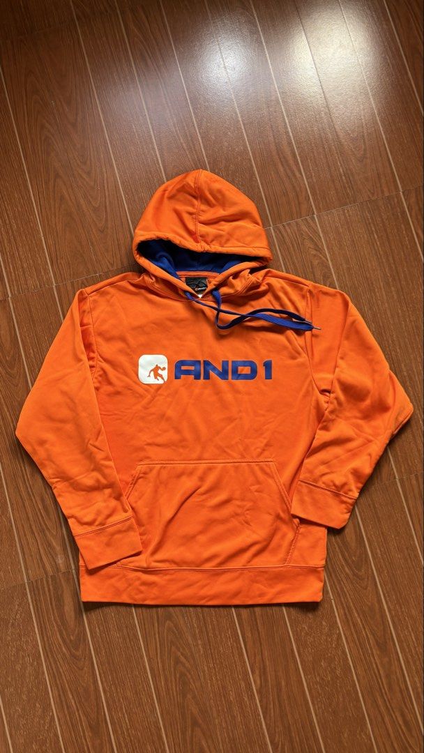 AND1 Orange Hoodie M/M (Category: Coats, Jackets and Outerwear) located in San Pablo. Submitted by alem12 (Listing ID 1445264368, Image 1). Description: - Orange AND1 hoodie - Blue drawstring and inner hood lining - Front kangaroo pocket - Size: Medium (M) - Made in China - Ideal for casual wear or sports.