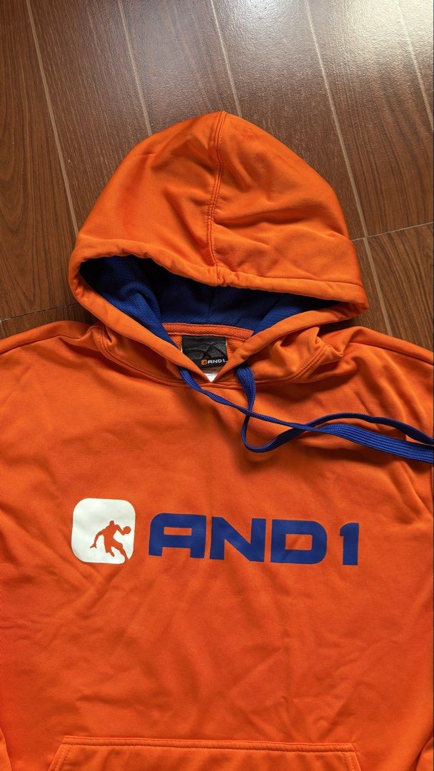 AND1 Orange Hoodie M/M (Category: Coats, Jackets and Outerwear) located in San Pablo. Submitted by alem12 (Listing ID 1445264368, Image 2). Description: - Orange AND1 hoodie - Blue drawstring and inner hood lining - Front kangaroo pocket - Size: Medium (M) - Made in China - Ideal for casual wear or sports.