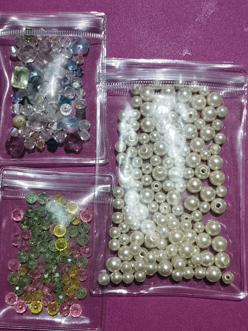 Assorted Craft Beads - Pearls, Crystals, and Gemstones (Category: Craft Supplies & Tools) located in Del Monte. Submitted by anitagalan89774 (Listing ID 1445327951, Image 1). Description: - Assorted beads perfect for all your crafting needs. - Bag 1: Creamy white pearl beads in various sizes. - Bag 2: Clear and blue-toned faceted crystal beads. - Bag 3: Colorful faceted gemstone beads (pink, green, yellow). - Ideal for making jewelry or adding em