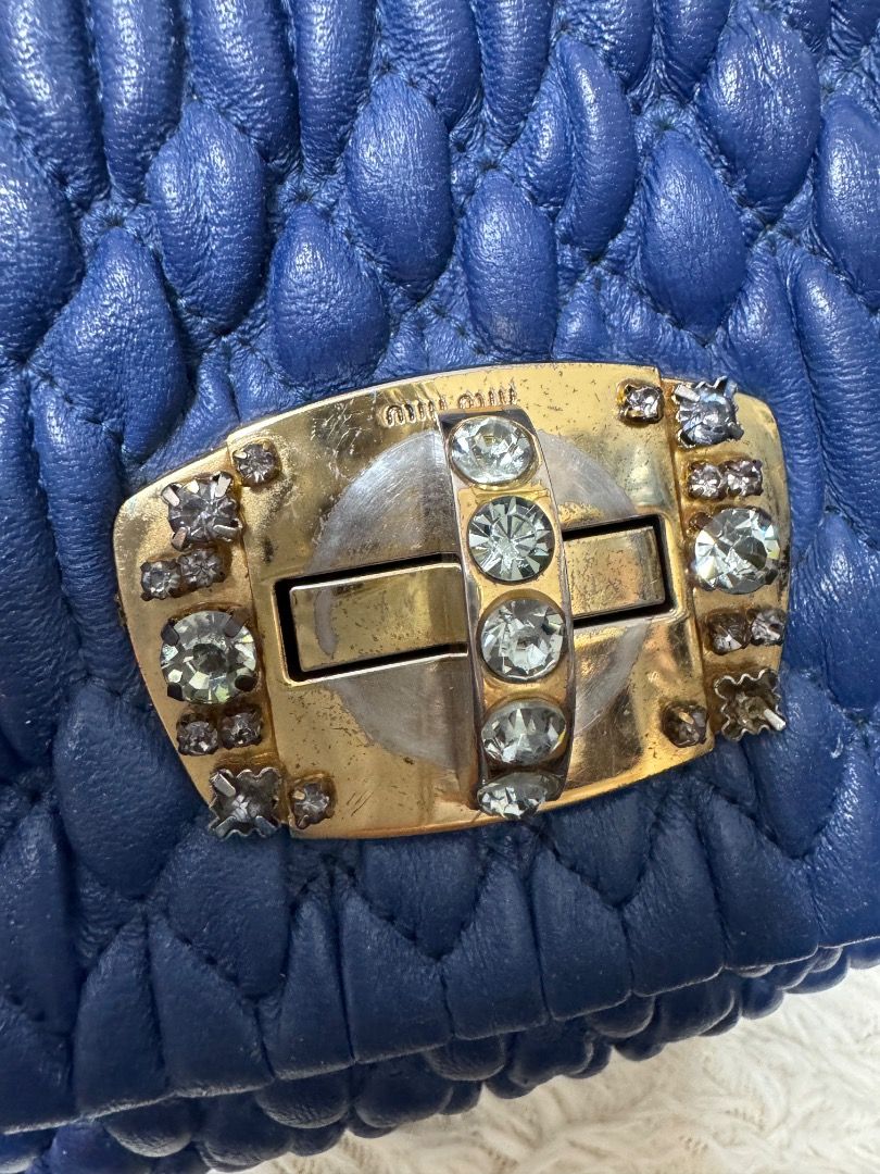 Blue Ruched Leather Handbag with Embellished Clasp (Category: Luxury Bags & Wallets) located in Malolos. Submitted by urban_thrift_09 (Listing ID 1445334411, Image 2). Description: - Navy blue ruched leather handbag - Gold-tone clasp with clear embellishments - Braided leather strap with detachable gold clip .