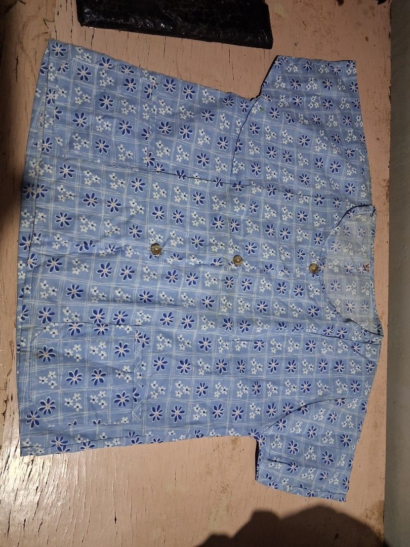 Blue Striped and Floral Button-Up Tops (2 pcs) (Category: Babies & Kids Fashion) located in Cabanatuan. Submitted by ronnelpena (Listing ID 1445322094, Image 2). Description: - Set of two short-sleeved button-up tops. - Top 1: Blue vertical stripes with small circular patterns. - Top 2: Light blue with a white and blue floral print. - Both tops have functional front buttons. - Both tops include convenient pockets. - Ideal for comfortable and casu