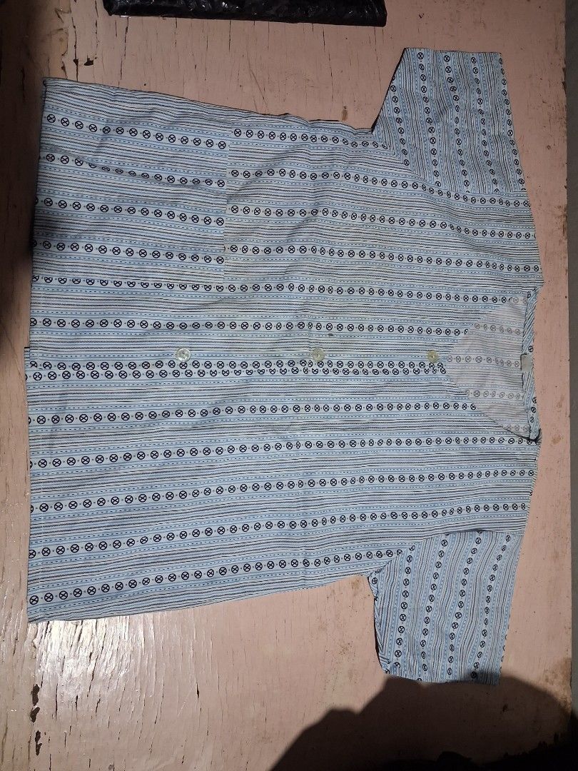 Blue Striped and Floral Button-Up Tops (2 pcs) (Category: Babies & Kids Fashion) located in Cabanatuan. Submitted by ronnelpena (Listing ID 1445322094, Image 1). Description: - Set of two short-sleeved button-up tops. - Top 1: Blue vertical stripes with small circular patterns. - Top 2: Light blue with a white and blue floral print. - Both tops have functional front buttons. - Both tops include convenient pockets. - Ideal for comfortable and casu