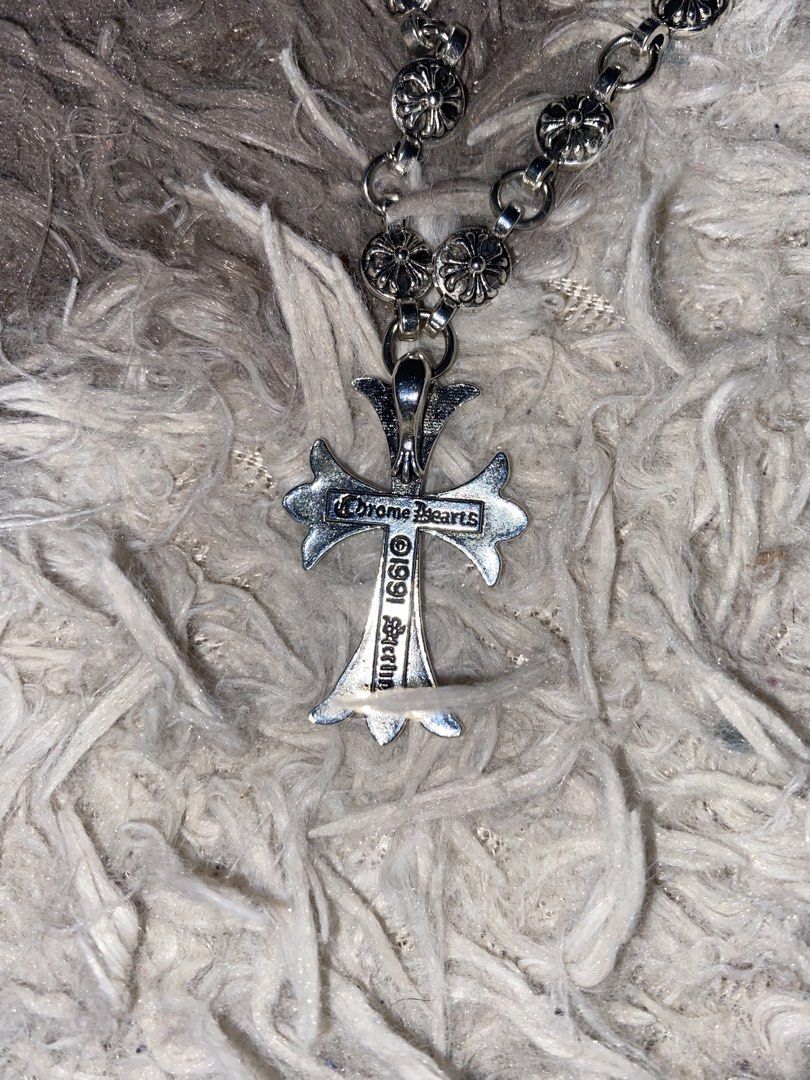 Chrome Hearts Cross Necklace (Category: Necklaces) located in Caloocan City. Submitted by remythrift (Listing ID 1445261747, Image 2). Description: - Authentic Chrome Hearts necklace - Iconic cross pendant with intricate detailing - Silver chain with small cross charms - Engraved with 'Chrome Hearts' and '1999' - Perfect statement piece for an edgy look.