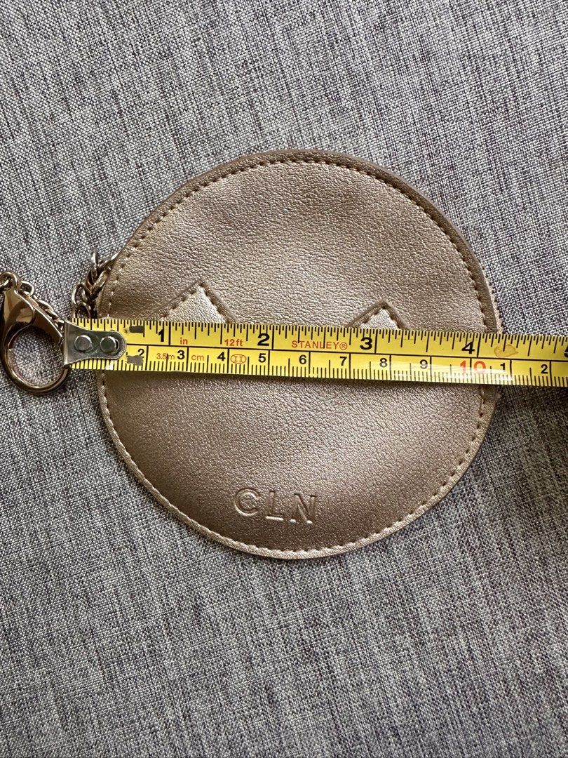 CLN Rose Gold Round Coin Pouch Keychain (Category: Purses & Pouches) located in Quezon City. Submitted by k_prelovedpieces (Listing ID 1445273655, Image 3). Description: - Cute round coin pouch from CLN - Rose gold color with a stylish zig-zag design - Features an attached keychain for easy carrying - Measures approximately 4 inches across - Ideal for organizing small essentials like coins, keys, or earbuds.