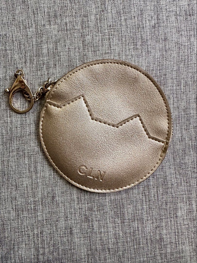 CLN Rose Gold Round Coin Pouch Keychain (Category: Purses & Pouches) located in Quezon City. Submitted by k_prelovedpieces (Listing ID 1445273655, Image 1). Description: - Cute round coin pouch from CLN - Rose gold color with a stylish zig-zag design - Features an attached keychain for easy carrying - Measures approximately 4 inches across - Ideal for organizing small essentials like coins, keys, or earbuds.