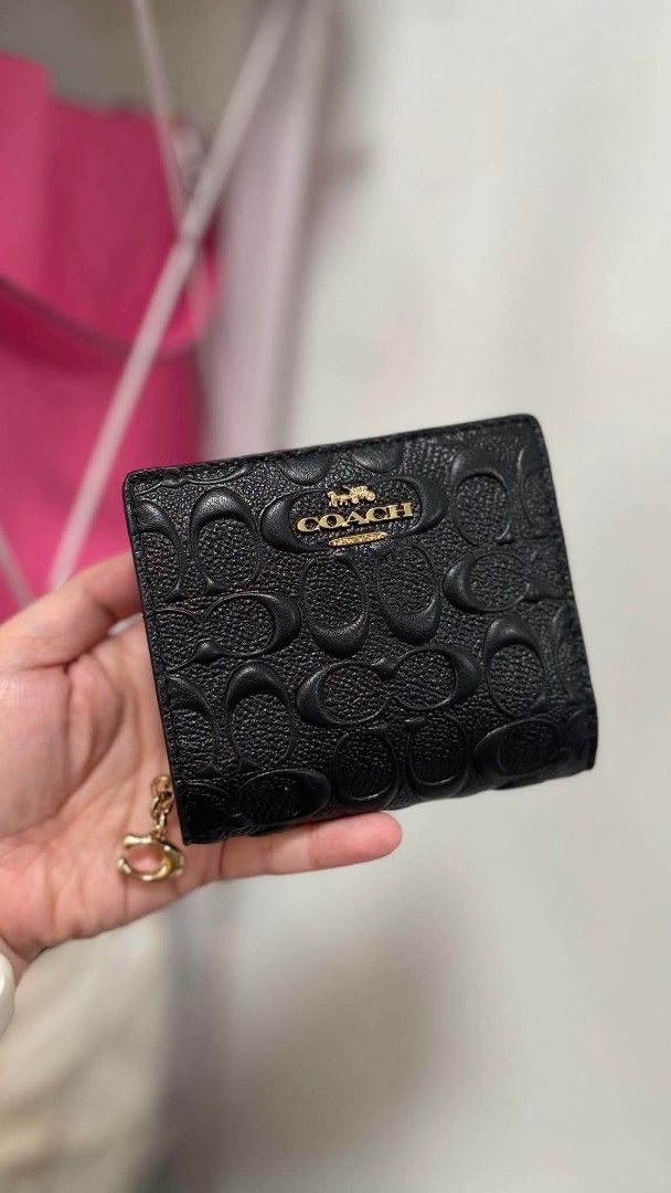 Coach Embossed Signature Bifold Wallet (Category: Luxury Bags & Wallets) located in Manila. Submitted by seresa_04 (Listing ID 1445364342, Image 1). Description: - Authentic Coach bifold wallet - Signature C pattern embossed all over - Comes with a small charm - Available in black and beige.