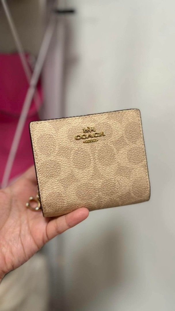 Coach Embossed Signature Bifold Wallet (Category: Luxury Bags & Wallets) located in Manila. Submitted by seresa_04 (Listing ID 1445364342, Image 2). Description: - Authentic Coach bifold wallet - Signature C pattern embossed all over - Comes with a small charm - Available in black and beige.