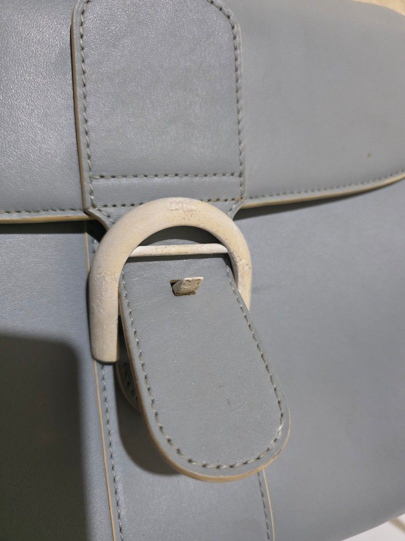 Delvaux Brillant Leather Handbag (Category: Luxury Bags & Wallets) located in Lemery. Submitted by venus23 (Listing ID 1445355787, Image 3). Description: - Genuine grey leather handbag - Unique buckle closure - Versatile: includes top handle and shoulder strap - Interior also in grey leather - Minor signs of wear on the buckle - Ideal for everyday use.